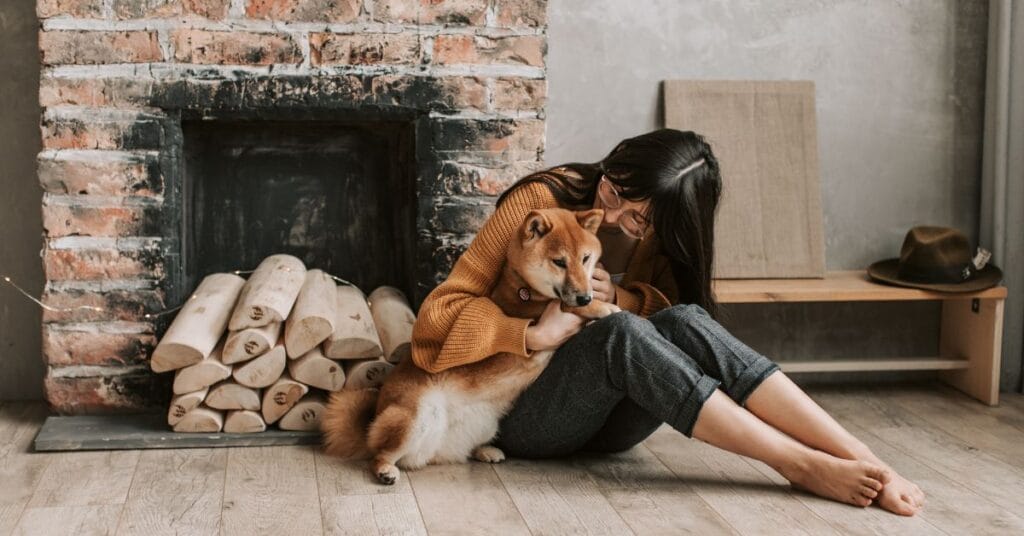Woman hugging pet dog at home